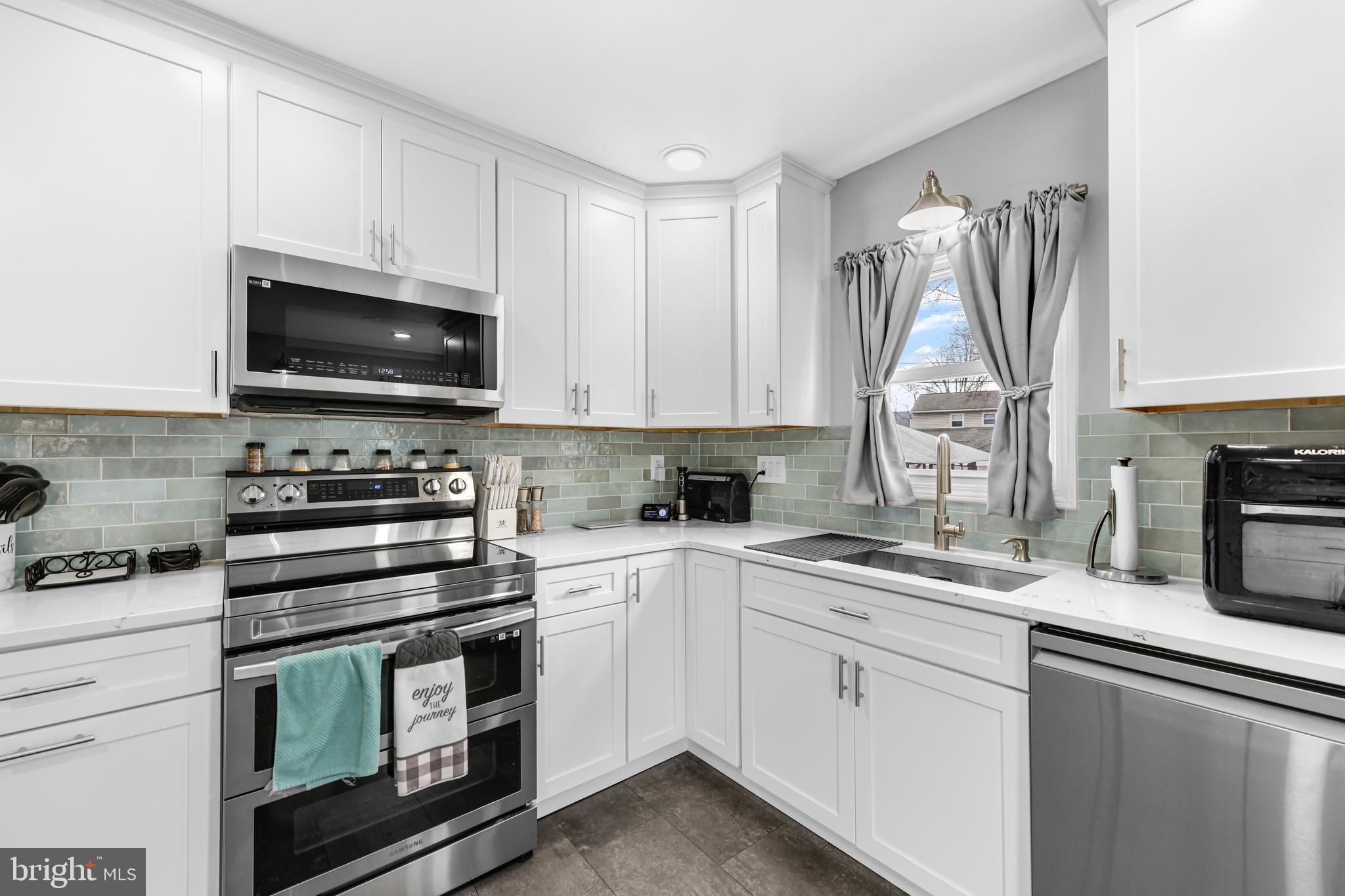 203 Eric Avenue Reading, PA 19607 - Photo 9 of 46 a kitchen with white cabinets stainless steel appliances and sink