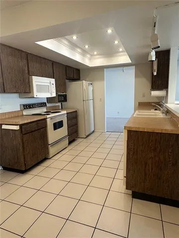 an empty room with windows and chandelier fan