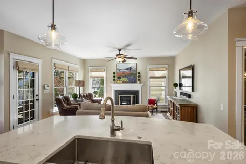 a living room with furniture a chandelier and a fireplace