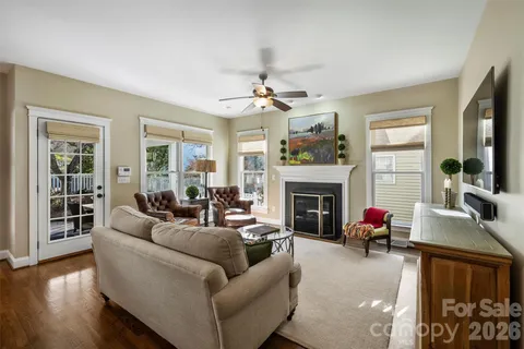 a living room with furniture a fireplace and a large window
