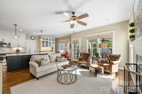 a living room with furniture kitchen view and a large window