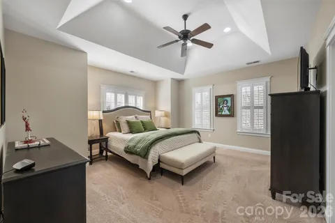 a spacious bedroom with a bed and a chandelier