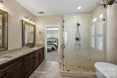 a spacious bathroom with a granite countertop sink mirror and shower