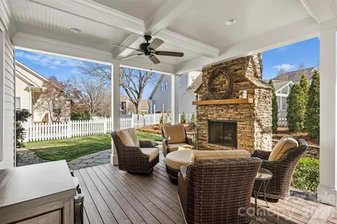 a living room with furniture a fireplace and a floor to ceiling window