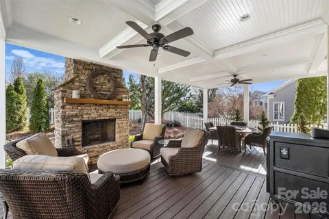 a living room with furniture a fireplace and a ceiling fan