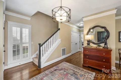 a view of a hallway with wooden floor windows and a chandelier