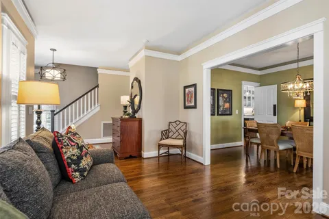 a living room with furniture and a dining table with wooden floor