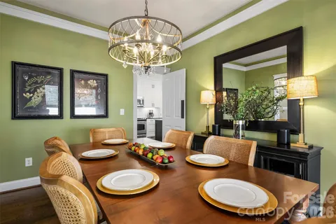 a dining room with furniture a chandelier and wooden floor