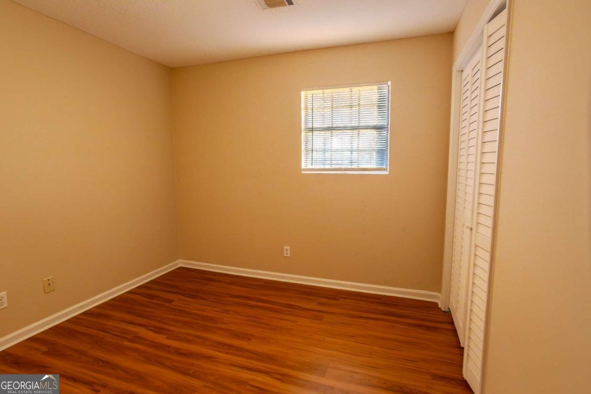 121 Trapper Trail Blackshear, GA 31516 - Photo 15 of 21 an empty room with wooden floor and windows