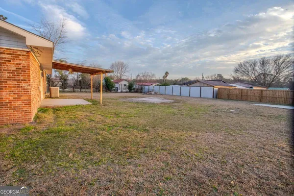 a view of a house with a yard and sitting area