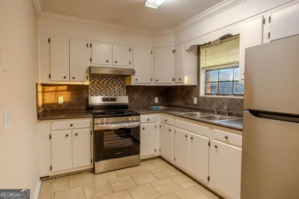 a kitchen with granite countertop white cabinets and white appliances