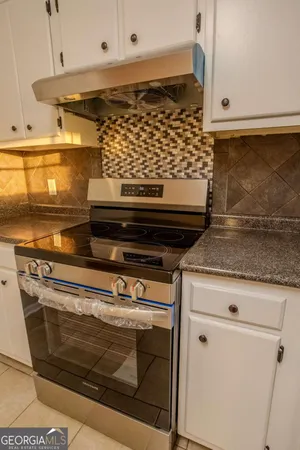 a stove top oven sitting inside of a kitchen