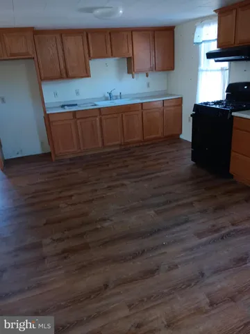 a kitchen with granite countertop wooden cabinets a sink and a stove