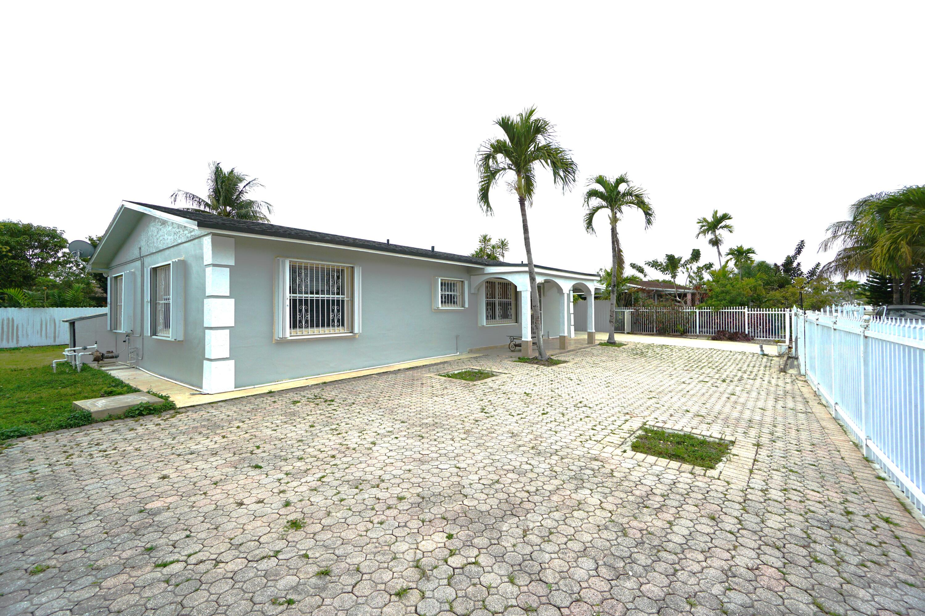 15520 Southwest 302nd Street Homestead, FL 33033 - Photo 1 of 20 a backyard of a house with potted plants and palm trees