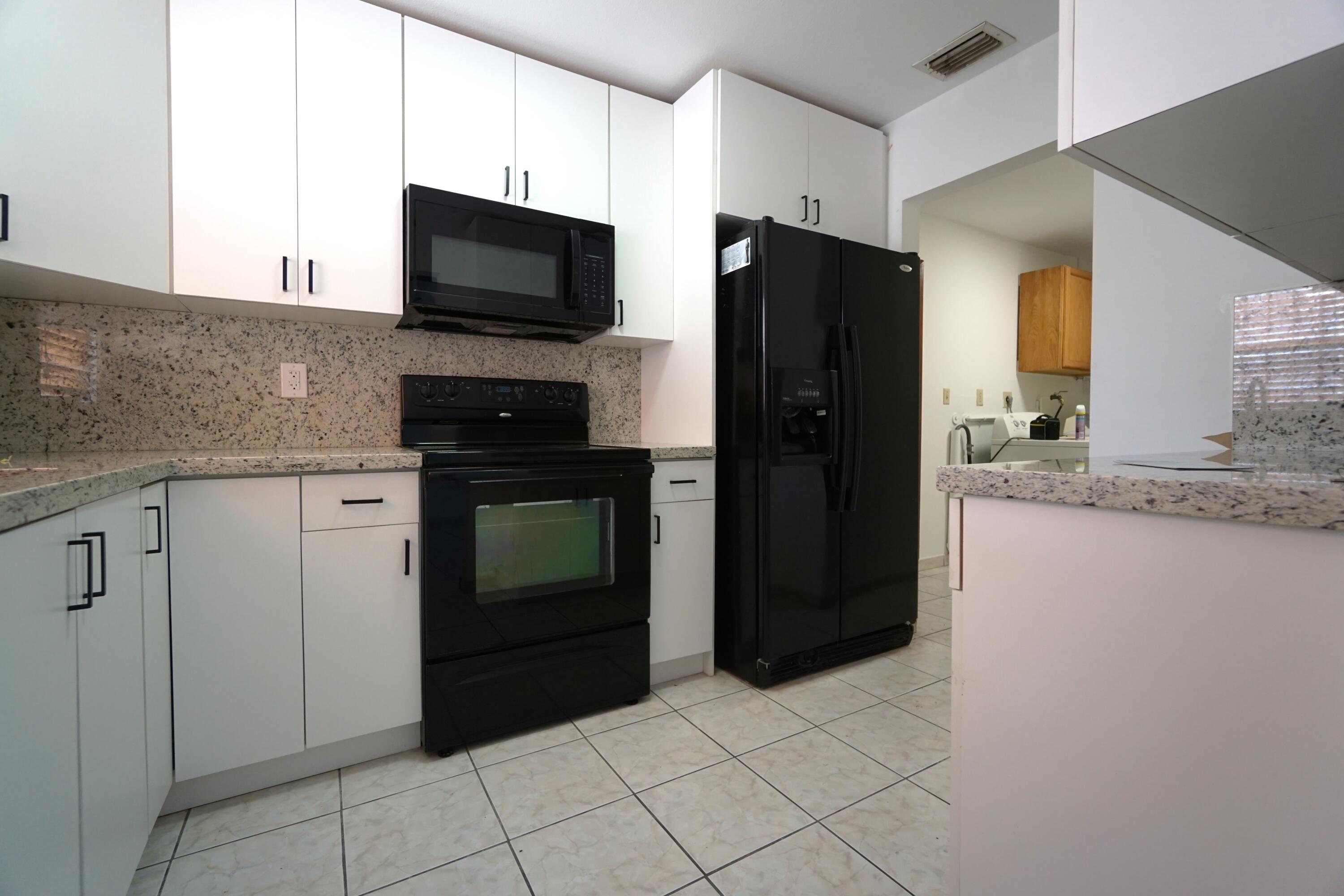 15520 Southwest 302nd Street Homestead, FL 33033 - Photo 16 of 20 a kitchen with stainless steel appliances granite countertop a refrigerator and a stove top oven