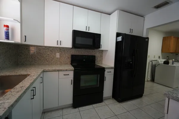 a kitchen with a refrigerator stove and cabinets