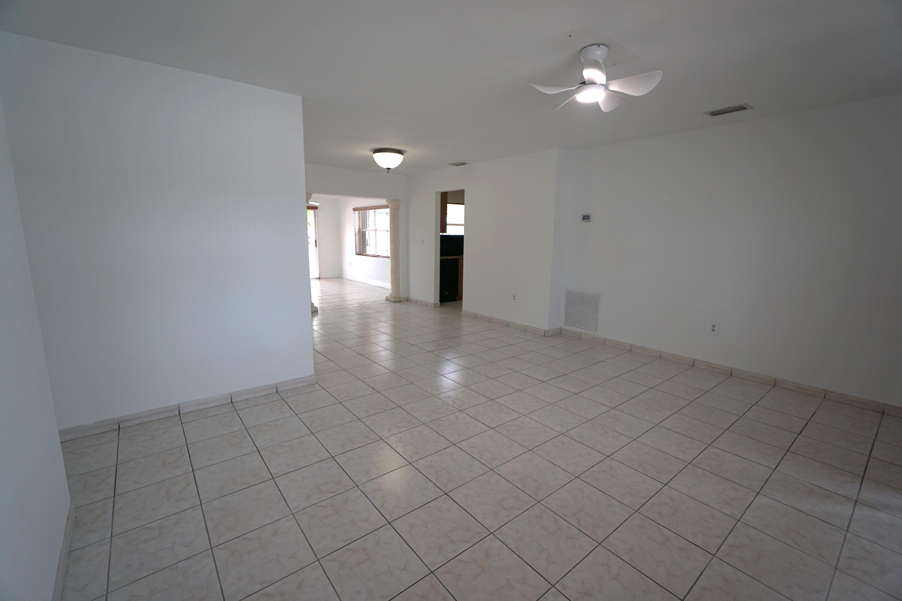 15520 Southwest 302nd Street Homestead, FL 33033 - Photo 9 of 20 an empty room with chandelier fan and window