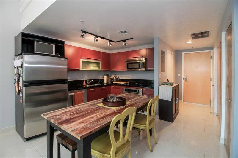 253 Northeast 2nd Street, Unit 421 Miami, FL 33132 - Photo 16 of 39 a kitchen with a table chairs refrigerator and microwave