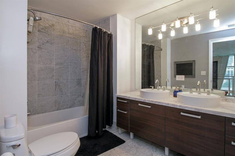 253 Northeast 2nd Street, Unit 421 Miami, FL 33132 - Photo 8 of 39 a bathroom with a double vanity sink toilet mirror and shower