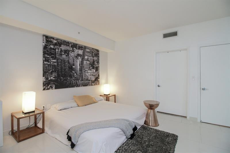 253 Northeast 2nd Street, Unit 421 Miami, FL 33132 - Photo 9 of 39 a bedroom with a bed and a painting on the wall
