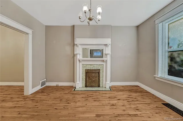 a view of an empty room with a window and fireplace