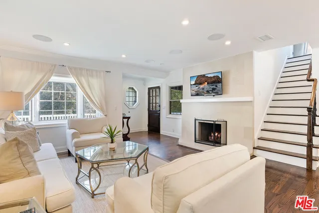a living room with furniture a fireplace and a large window