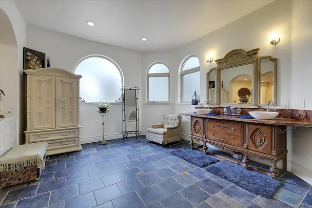 a spacious bathroom with a mirror a sink and a mirror