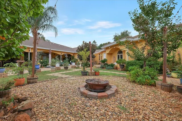 a view of a house with backyard and sitting area