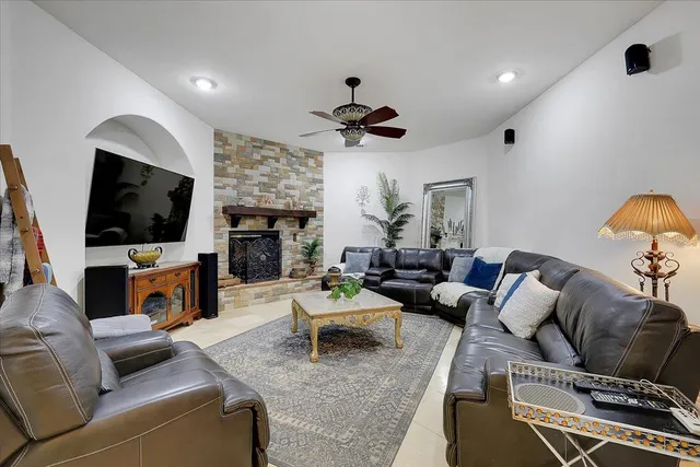 a living room with furniture a fireplace and a flat screen tv