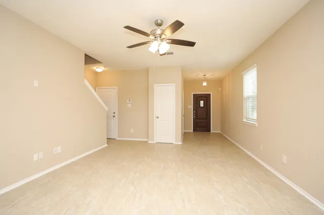 a view of an empty room with a ceiling fan