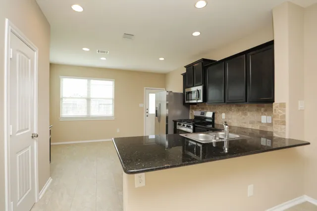 a kitchen with stainless steel appliances granite countertop a sink stove and microwave