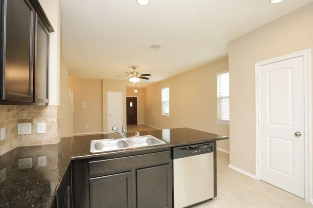 a kitchen with stainless steel appliances granite countertop a sink a stove and a refrigerator