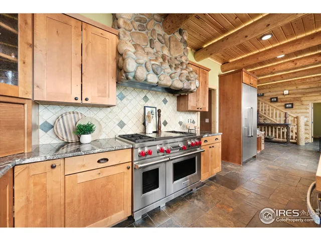 a kitchen with stainless steel appliances granite countertop a sink a stove and a refrigerator