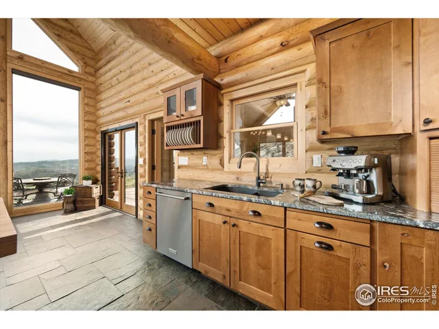 a kitchen with stainless steel appliances granite countertop a stove and a view of living room