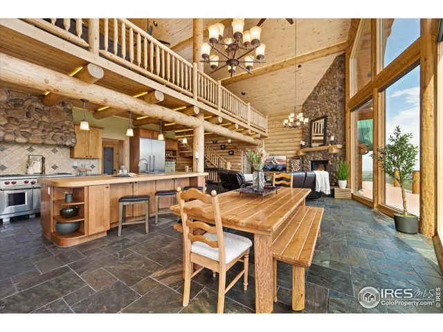 a dining hall view with a large dining table and chairs with wooden floor