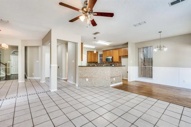 a view of a living room a ceiling fan and refrigerator