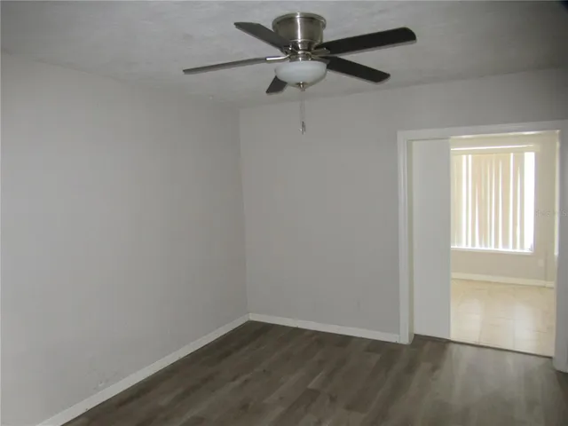 a view of a small space with wooden floor and a fan