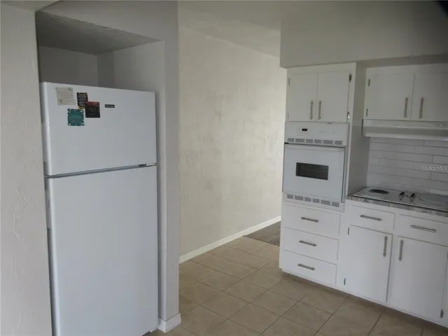 a kitchen with granite countertop white cabinets and white appliances