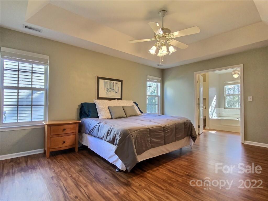870 Knightsbridge Road Fort Mill, SC 29708 - Photo 13 of 25 a spacious bedroom with a large bed and a chandelier