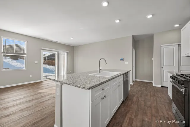 a kitchen with sink stove and refrigerator