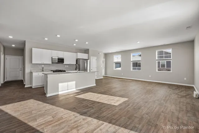 a large kitchen with cabinets and wooden floor