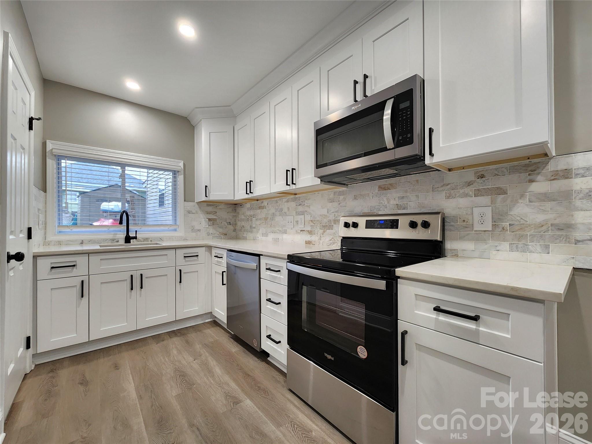 96 1/2 Elm Street Cramerton, NC 28032 - Photo 5 of 20 a kitchen with granite countertop white cabinets stainless steel appliances and a sink