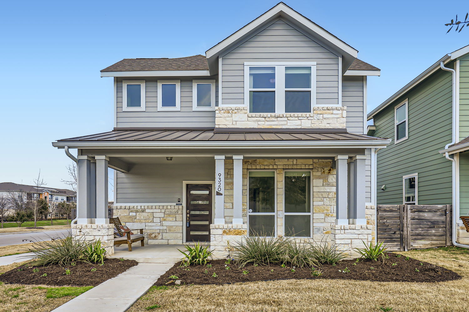 9320 Cattle Baron Path Austin, TX 78747 - Photo 1 of 1 View of front of property featuring a porch, a shingled roof, a standing seam roof, metal roof, and stone siding