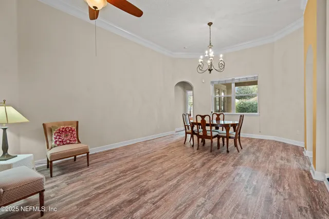 a living room with furniture a dining table and a chandelier