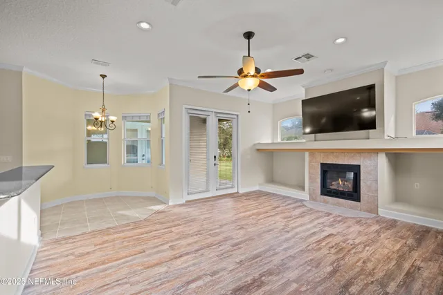 a view of a livingroom with a fireplace a chandelier and wooden floor