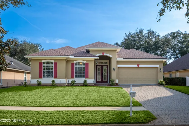 a front view of a house with a yard and trees