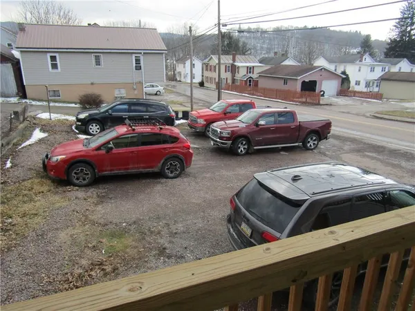 a front view of a house with cars parked