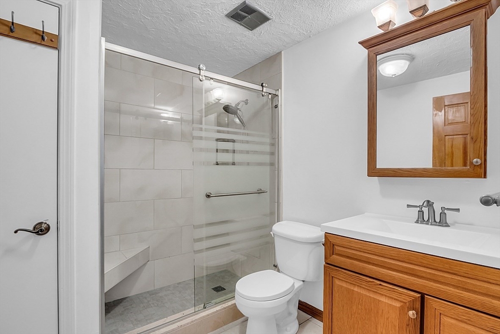 10 Mill Street, Unit B Maynard, MA 01754 - Photo 12 of 21 a bathroom with a shower a sink a toilet and a mirror