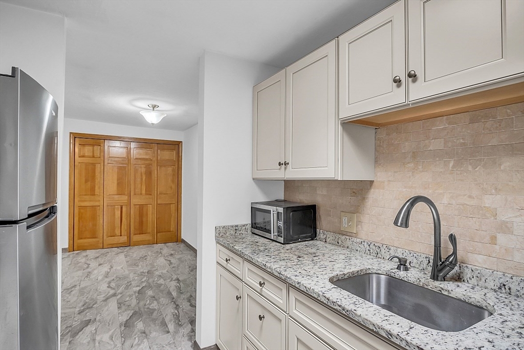 10 Mill Street, Unit B Maynard, MA 01754 - Photo 10 of 21 a kitchen with granite countertop a sink a refrigerator and window