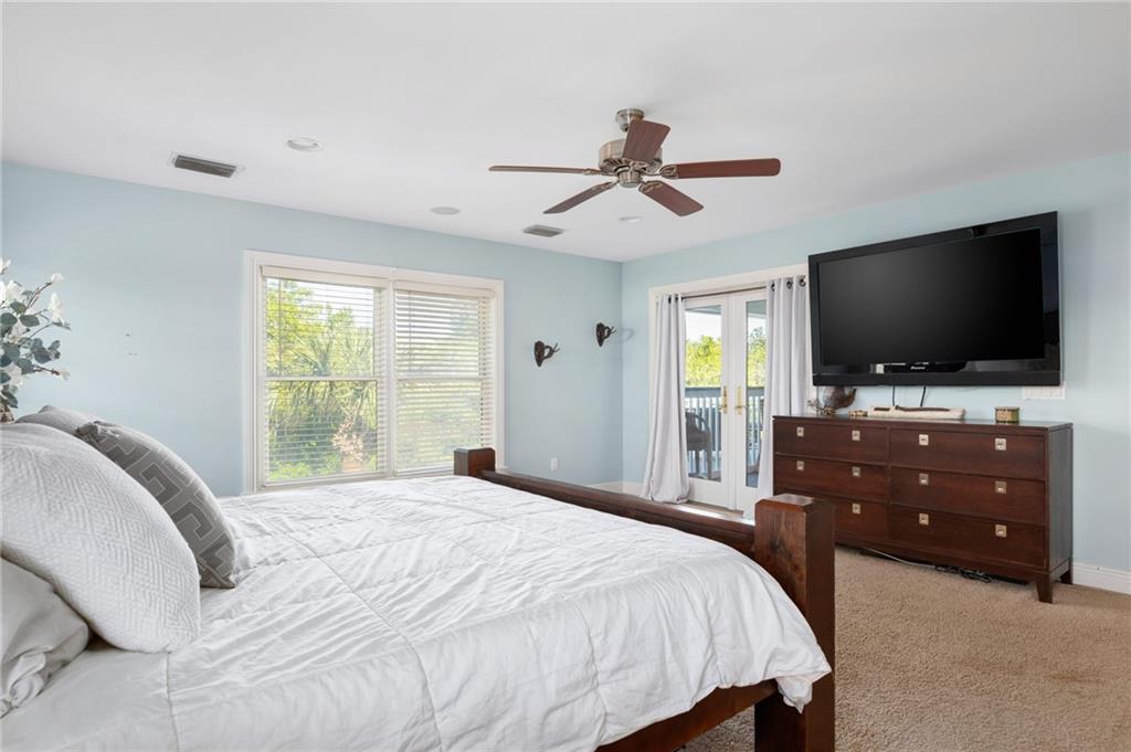 5440 95th Street Sebastian, FL 32958 - Photo 17 of 36 a bedroom with a bed and a flat screen tv on dresser
